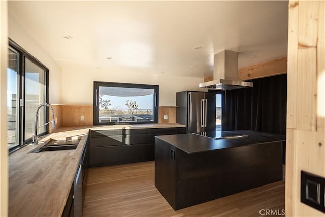 3977 Sage Ave, Yucca Valley, CA 92284 - kitchen featuring freestanding refrigerator, island range hood, black electric cooktop, and plenty of natural light