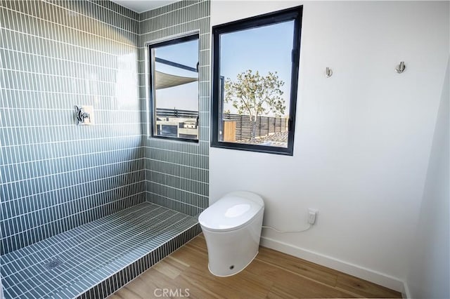 3977 Sage Ave, Yucca Valley, CA 92284 - bathroom featuring toilet, baseboards, wood finished floors, and a tile shower