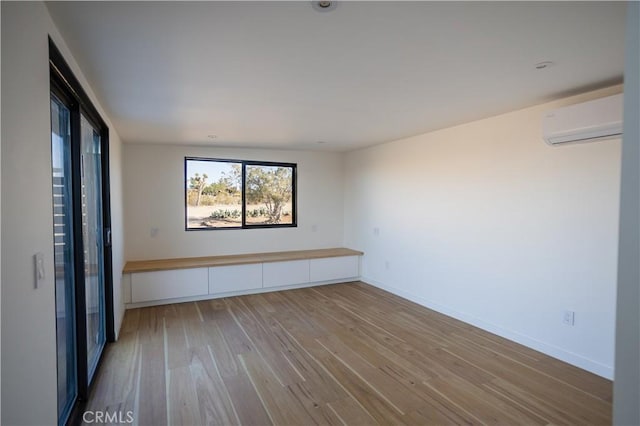 3977 Sage Ave, Yucca Valley, CA 92284 - spare room featuring a wall mounted air conditioner, wood finished floors, and baseboards
