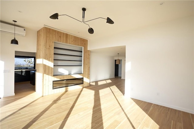 3977 Sage Ave, Yucca Valley, CA 92284 - unfurnished room featuring a wall unit AC, light wood-style flooring, and baseboards