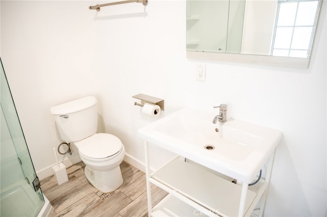 12907 Sunburst St, Los Angeles, CA 91331 - bathroom featuring a shower with door, toilet, wood finished floors, and baseboards