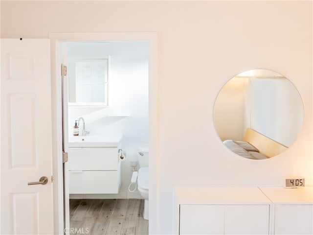 12907 Sunburst St, Los Angeles, CA 91331 - half bathroom with vanity, wood finished floors, and toilet