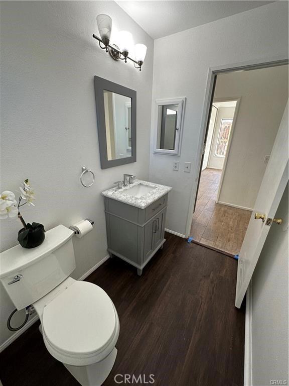 3030 Twincreek Ave, Palmdale, CA 93551 - bathroom with vanity, wood finished floors, toilet, and baseboards