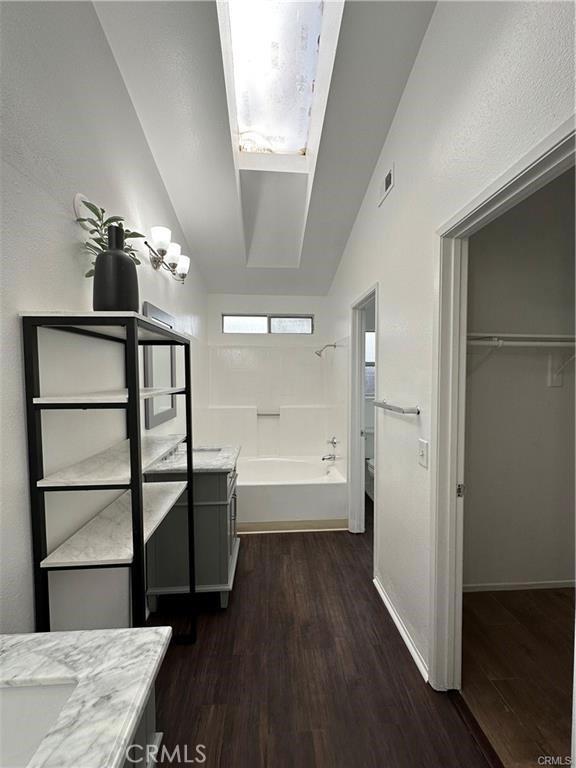 3030 Twincreek Ave, Palmdale, CA 93551 - full bathroom featuring wood finished floors, vaulted ceiling, vanity, shower / bath combination, and a spacious closet