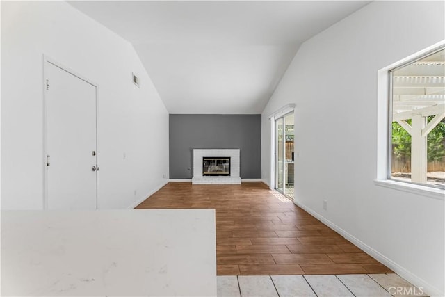 3030 Twincreek Ave, Palmdale, CA 93551 - unfurnished living room featuring lofted ceiling, wood finished floors, and a brick fireplace