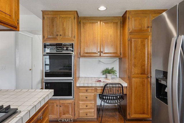 17442 Parker Dr, Tustin, CA 92780 - kitchen featuring stainless steel refrigerator with ice dispenser, tile countertops, recessed lighting, brown cabinetry, and dark wood-type flooring