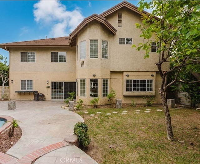 18853 Beechtree Ln, Porter Ranch, CA 91326 - back of property featuring a patio area, stucco siding, and concrete driveway