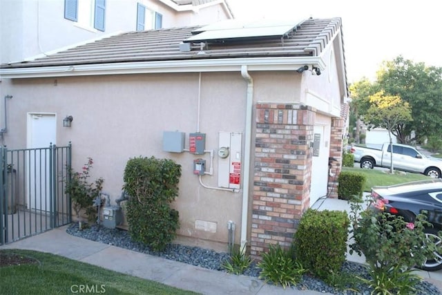 26246 Reade Pl, Stevenson Ranch, CA 91381 - view of side of property with stucco siding and roof mounted solar panels