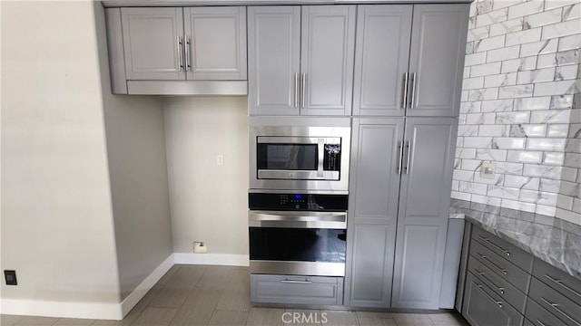 26246 Reade Pl, Stevenson Ranch, CA 91381 - kitchen featuring stainless steel appliances, gray cabinetry, and light stone counters