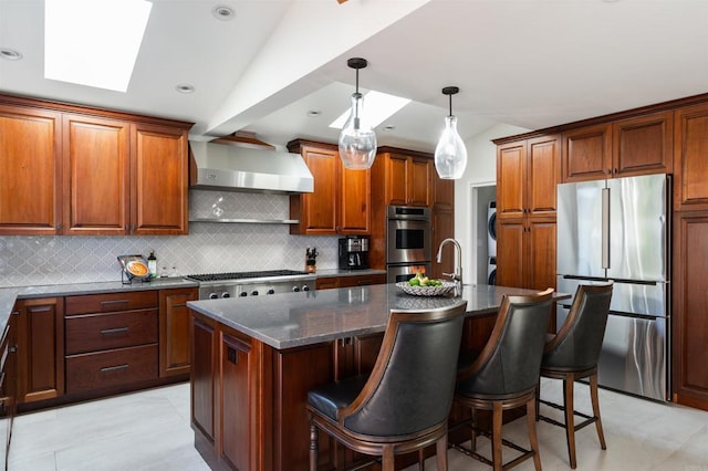 2675 Clove St, San Diego, CA 92106 - kitchen featuring stainless steel appliances, wall chimney range hood, backsplash, a center island with sink, and a breakfast bar area