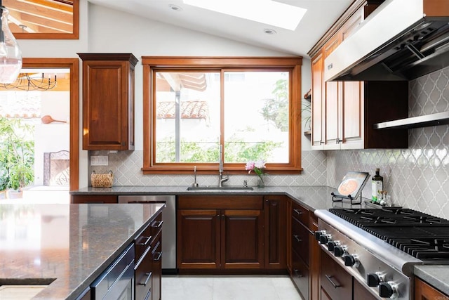 2675 Clove St, San Diego, CA 92106 - kitchen featuring stainless steel appliances, lofted ceiling, exhaust hood, dark stone countertops, and a skylight