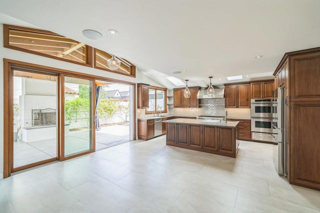 2675 Clove St, San Diego, CA 92106 - kitchen with lofted ceiling, stainless steel appliances, plenty of natural light, decorative backsplash, and a kitchen island with sink