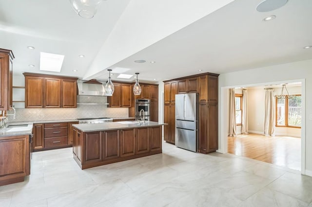 2675 Clove St, San Diego, CA 92106 - kitchen with stainless steel appliances, tasteful backsplash, an island with sink, brown cabinets, and a skylight