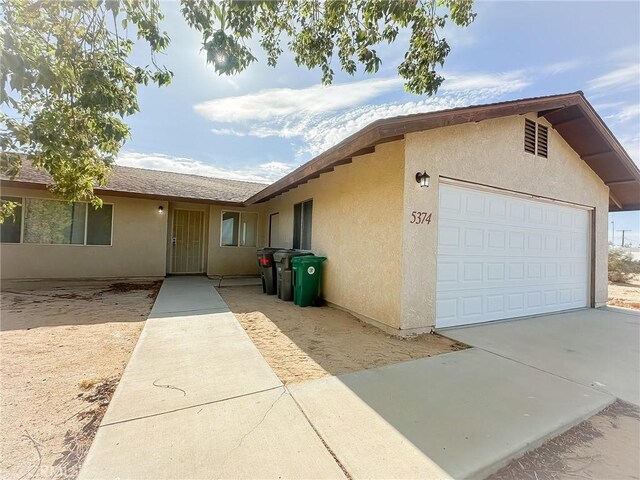 5374 Morongo Rd Unit 29, Palms, CA 92277 - view of front of house featuring stucco siding, a garage, and concrete driveway