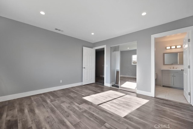 7719 Nestle Ave, Reseda, CA 91335 - unfurnished bedroom with wood finished floors, baseboards, recessed lighting, connected bathroom, and a closet