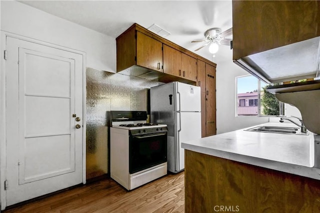 305 Raymondale Dr Unit L, South Pasadena, CA 91030 - kitchen with white appliances, ceiling fan, wood finished floors, light countertops, and brown cabinets