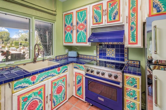 4843 La Jacaranda, Rancho Santa Fe, CA 92067 - kitchen featuring under cabinet range hood, stainless steel range, a sink, tile counters, and freestanding refrigerator