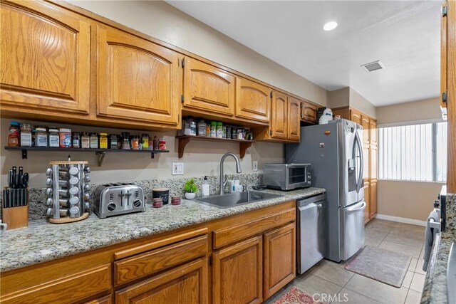 2011 W Katella Ave Unit 17, Anaheim, CA 92804 - kitchen featuring stainless steel appliances, open shelves, brown cabinets, light stone counters, and light tile patterned floors