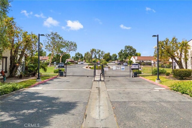 2011 W Katella Ave Unit 17, Anaheim, CA 92804 - view of asphalt road with street lights, a gate, and a gated entry