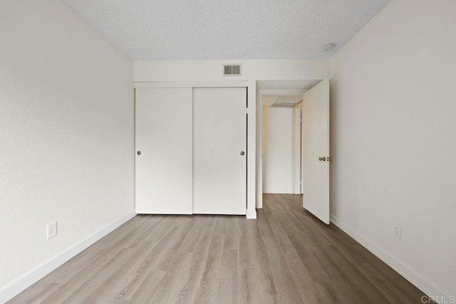 5938 Rancho Mission Rd Unit 133, San Diego, CA 92108 - unfurnished bedroom with wood finished floors, baseboards, a closet, and a textured ceiling