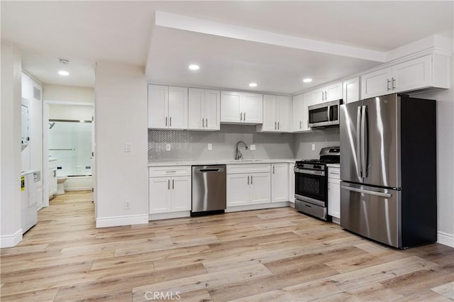 4071 Melrose Ave Unit 1, Los Angeles, CA 90029 - kitchen with stainless steel appliances, light countertops, white cabinetry, and recessed lighting