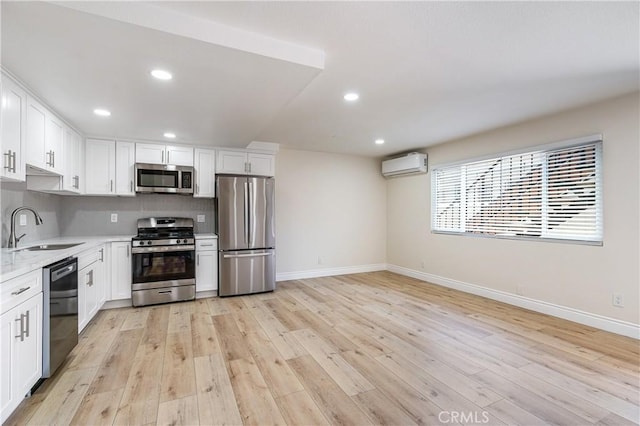4071 Melrose Ave Unit 1, Los Angeles, CA 90029 - kitchen with stainless steel appliances, a sink, baseboards, an AC wall unit, and recessed lighting