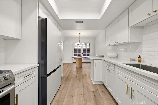 1202 Monte Sereno Dr, Thousand Oaks, CA 91360 - kitchen featuring white cabinets, high end fridge, stainless steel range, a tray ceiling, and ornamental molding