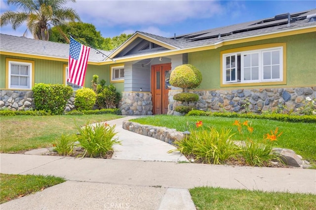 12071 Reva Dr, Garden Grove, CA 92840 - view of front of property with solar panels, a shingled roof, and stone siding
