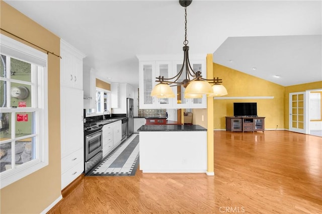12071 Reva Dr, Garden Grove, CA 92840 - kitchen featuring stainless steel appliances, dark countertops, white cabinetry, light wood finished floors, and lofted ceiling