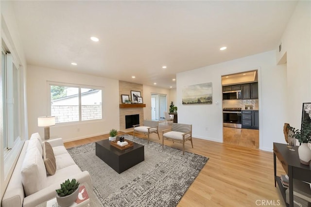 837 Ardmore Cir, Redlands, CA 92374 - living room featuring light wood-type flooring, a large fireplace, recessed lighting, and baseboards