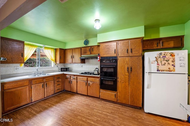 4320 Hamilton Ave, Oxnard, CA 93033 - kitchen featuring black appliances, wood finished floors, tasteful backsplash, and a sink