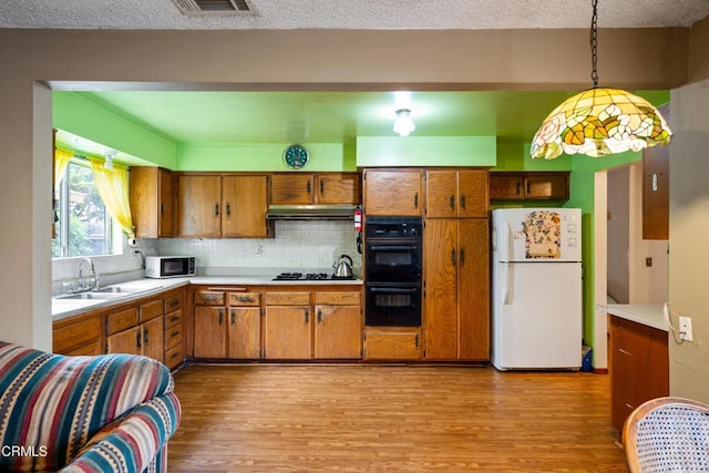 4320 Hamilton Ave, Oxnard, CA 93033 - kitchen featuring black appliances, brown cabinetry, light wood finished floors, and light countertops