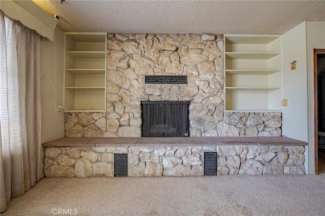1640 Shirley St, Merced, CA 95341 - unfurnished living room featuring a textured ceiling, built in shelves, a stone fireplace, and carpet