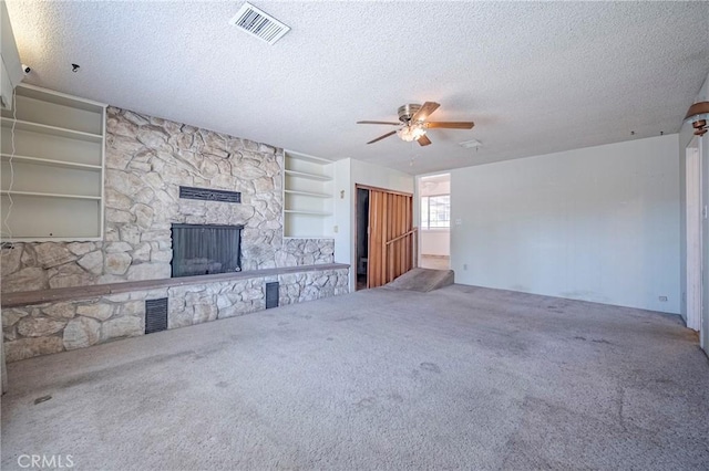 1640 Shirley St, Merced, CA 95341 - unfurnished living room with carpet, a ceiling fan, a textured ceiling, a stone fireplace, and built in features
