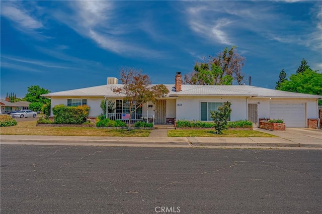 1640 Shirley St, Merced, CA 95341 - ranch-style home with an attached garage, driveway, a chimney, stucco siding, and covered porch