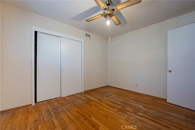 1640 Shirley St, Merced, CA 95341 - unfurnished bedroom with hardwood / wood-style floors, wallpapered walls, a closet, and ceiling fan