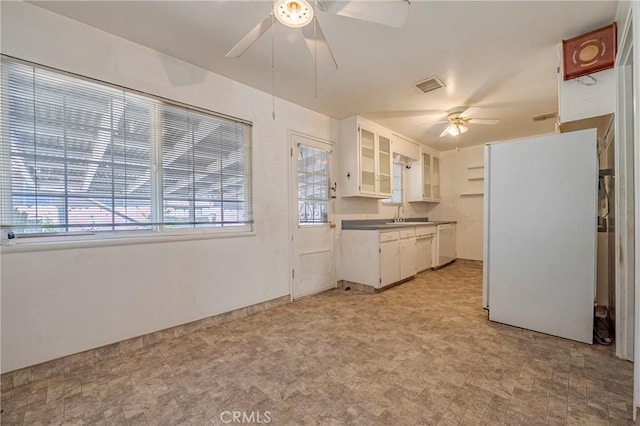 1640 Shirley St, Merced, CA 95341 - kitchen with a ceiling fan, white appliances, glass insert cabinets, white cabinetry, and light floors