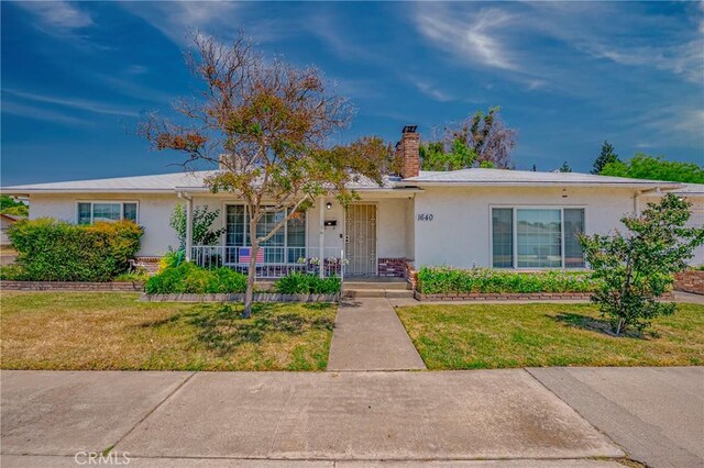 1640 Shirley St, Merced, CA 95341 - ranch-style home with stucco siding, a porch, a chimney, and a front yard