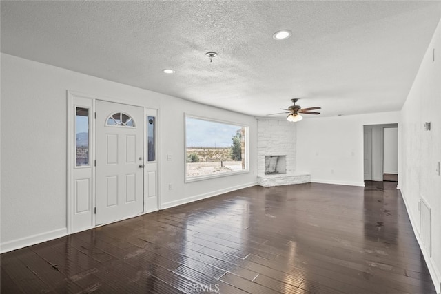 18531 E Palmdale Blvd, Palmdale, CA 93591 - unfurnished living room featuring a textured ceiling, a ceiling fan, a stone fireplace, baseboards, and wood finished floors