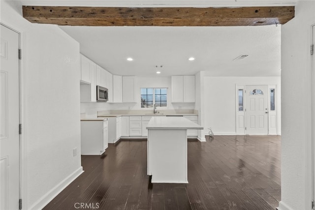 18531 E Palmdale Blvd, Palmdale, CA 93591 - kitchen with stainless steel microwave, a sink, dark wood-type flooring, baseboards, and a center island
