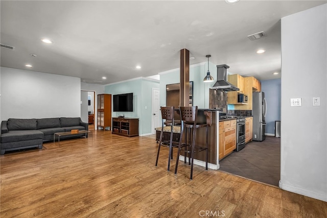 17508 Strathern St, Northridge, CA 91325 - kitchen featuring wall chimney exhaust hood, stainless steel appliances, dark countertops, recessed lighting, and wood finished floors