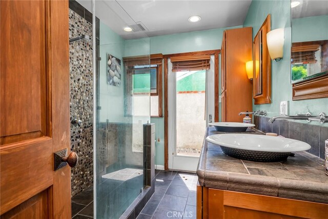 17508 Strathern St, Northridge, CA 91325 - bathroom with a shower stall, double vanity, stone tile flooring, and baseboards