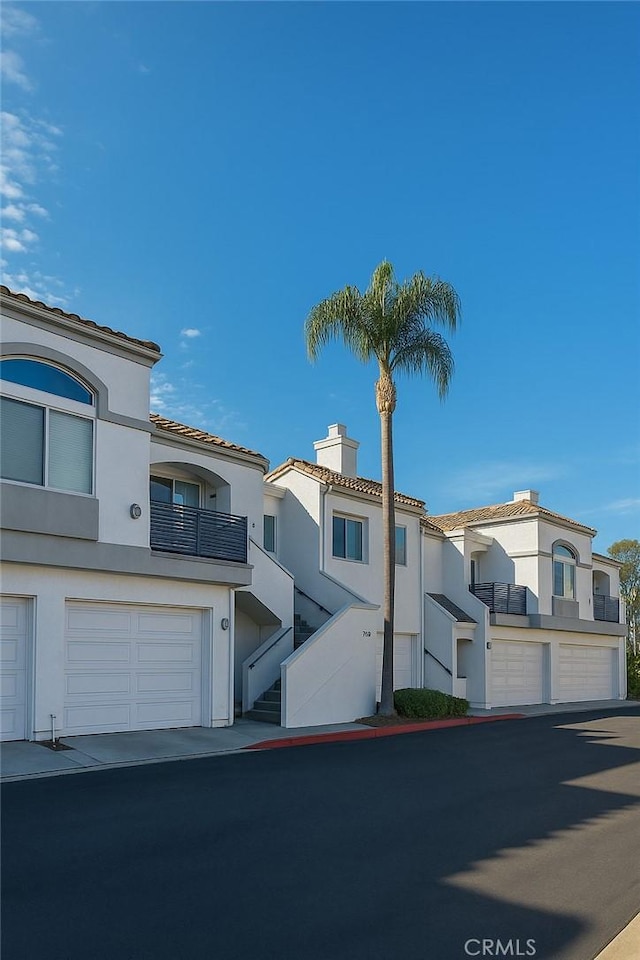 24982 La Pantera, Laguna Niguel, CA 92677 - view of front of home with stucco siding, a chimney, a tile roof, and an attached garage