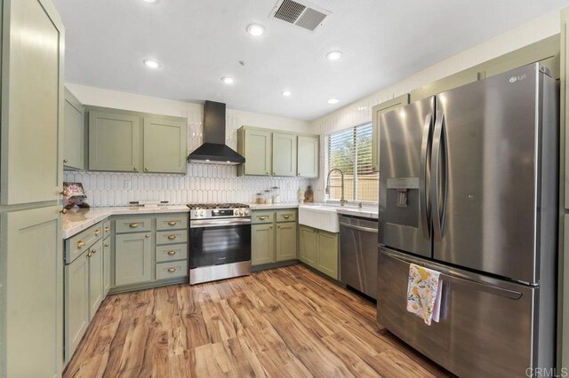 305 Cobblestone Pl, Santee, CA 92071 - kitchen featuring appliances with stainless steel finishes, wall chimney range hood, green cabinetry, light countertops, and recessed lighting