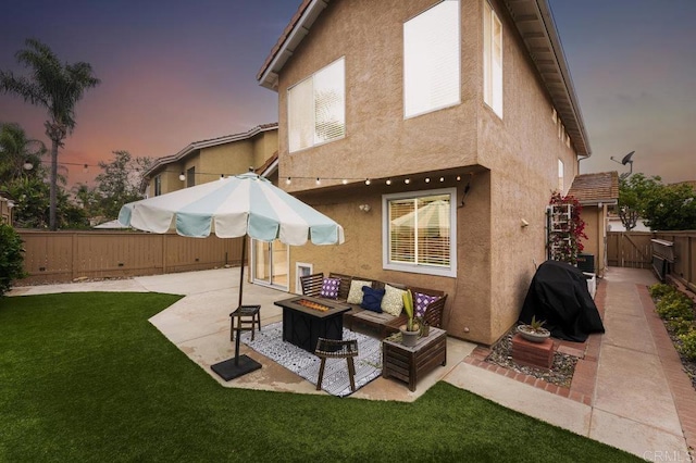 305 Cobblestone Pl, Santee, CA 92071 - back of house at dusk featuring stucco siding, a patio, a fenced backyard, and an outdoor living space with a fire pit