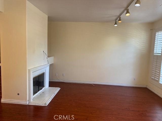 19 Softwind, Aliso Viejo, CA 92656 - unfurnished living room featuring rail lighting, wood finished floors, and a glass covered fireplace