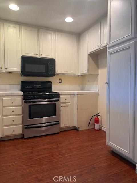 19 Softwind, Aliso Viejo, CA 92656 - kitchen featuring black microwave, stainless steel range with gas cooktop, white cabinets, dark wood-type flooring, and recessed lighting