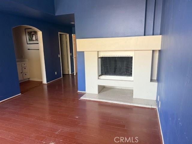 19 Softwind, Aliso Viejo, CA 92656 - unfurnished living room with arched walkways, wood finished floors, and a fireplace with raised hearth