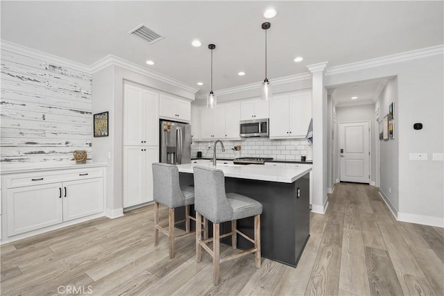 45437 Calle Cirros, Temecula, CA 92592 - kitchen with appliances with stainless steel finishes, tasteful backsplash, white cabinetry, light wood finished floors, and light countertops