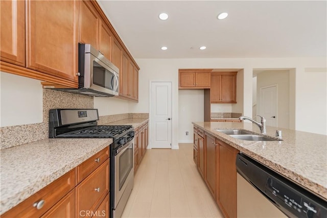 6611 Eucalyptus Ave, Chino, CA 91710 - kitchen with stainless steel appliances, a sink, brown cabinets, light stone countertops, and recessed lighting
